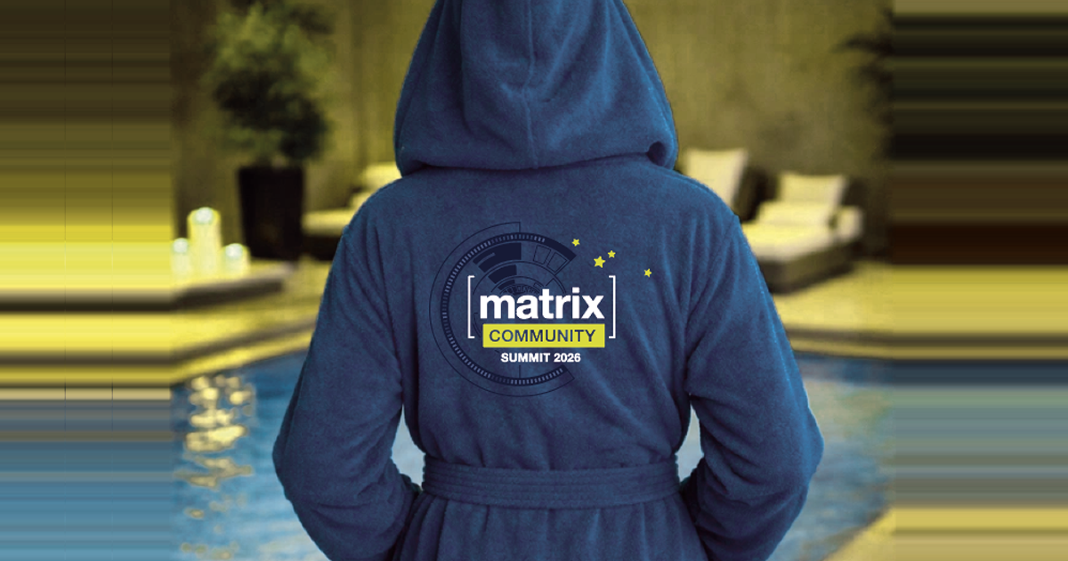 A picture of someone wearing a bathrobe, as seen from the back. There is the Matrix Community Summit logo on the back.